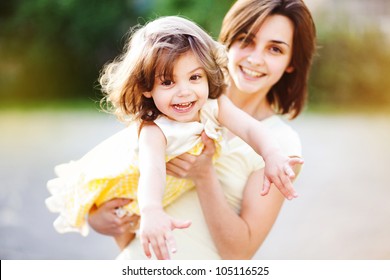 Young Mother With Child Outside On A Summer Day