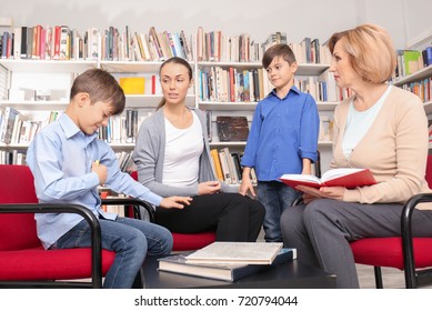 Young mother and children on meeting with teacher at school