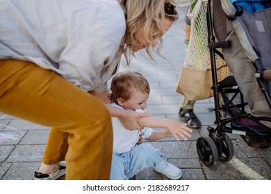 Young Mother Comforting Crying Little Girl Outdoor On Walk. Concept Of Disobedient Child