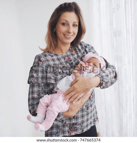 Similar – Mother giving bottle to her newborn