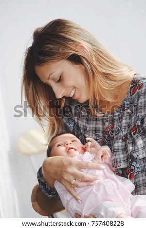 Similar – Mother giving bottle to her newborn