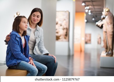 Young Mother And Daughter Exploring Antique Statues At Museum. Focus On Child 