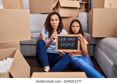 Young Mother And Daughter Sitting On The Floor At New Home Skeptic And Nervous, Frowning Upset Because Of Problem. Negative Person. 