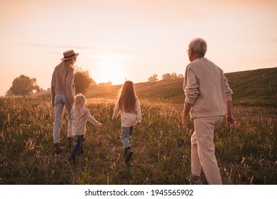 Young mother with daughters and grandmother walk together in the countryside - Powered by Shutterstock