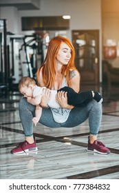 Young mother doing exercises with her little son in her arms