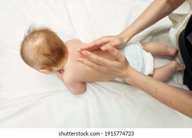 Young Mother Doing Massage On Baby Back. Body Health Problem. Baby Massage Concept. Infant Baby 3 Month Old Lying On Tummy. Point Of View Shot.