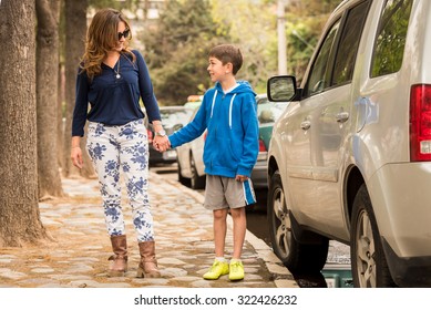 Young Mother Dropping Off Her Son At Soccer Practice.