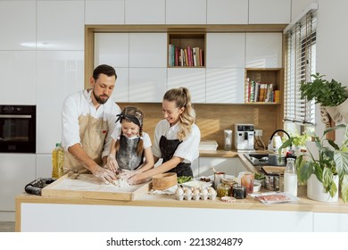 Young Mother And Father Kneading Dough Teaching Delighted Kid Cooking Baking Homemade Pizza Pasta Cookies Biscuits Gnocchi.