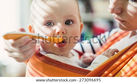 Mother with eating toddler.