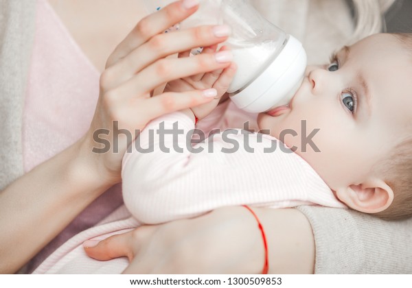 幼い母親は 小さな可愛い赤ちゃんに哺乳瓶のミルクを与えていた 生まれたばかりの赤ちゃんを家に持つ女性 お母さんが子供の世話をしてる 母乳で育てる代わりに の写真素材 今すぐ編集
