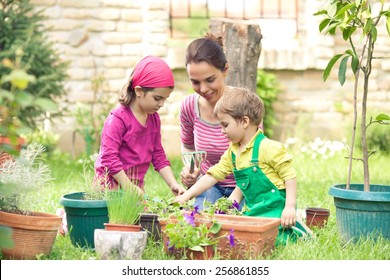 Jungmüttergarten mit ihren zwei süßen kleinen Kindern vor oder hinter dem Garten