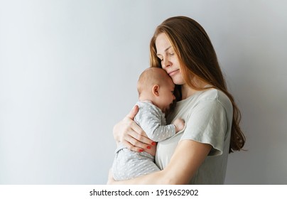 A young mother gently holds and hugs her little newborn daughter on a white background. Copy space for text. Happy mother's day. - Powered by Shutterstock
