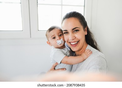 Young mother having fun taking selfie with her baby at home - Focus on mother face - Powered by Shutterstock