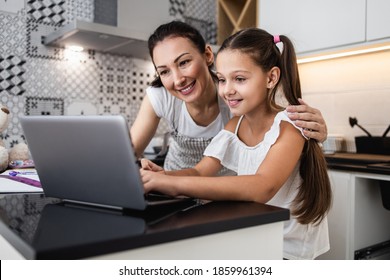 Young Mother Helping Her Daughter On E-learning Session During Covid-19 Pandemic Crisis Lockdown Or Quarantine. Illness Prevention And New Normal Concept.