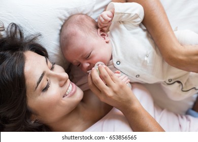 Young mother with her baby in bed - Shutterstock ID 653856565