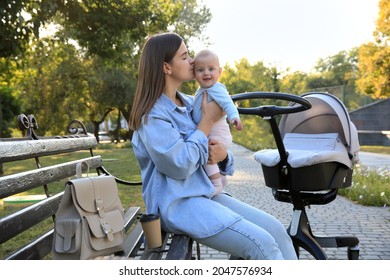 Young Mother With Her Baby On Bench In Park