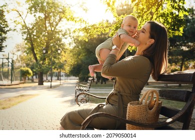 Young Mother With Her Cute Baby On Bench In Park