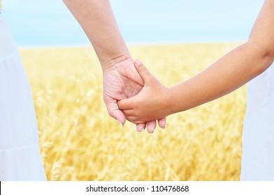 Young Mother And Her Daughter Holding Hands