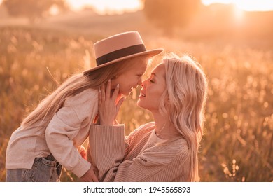 Young mother and her daughter look at each other with love in the countryside