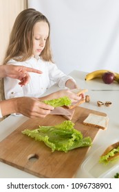 Young Mother And Her Kid Making School Sandwich For Lunch. Preparing For School. Lunch Box With Appetizing Food And School Bag On Kitchen Background.
Schoolgirl And Her Mom At Kitchen.