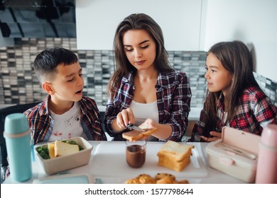 Young Mother And Her Kid Making School Sandwich For Lunch. Preparing For School. Lunch Box With Appetizing Food.