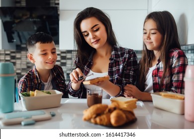 Young Mother And Her Kid Making School Sandwich For Lunch. Lunch Box With Appetizing Food.