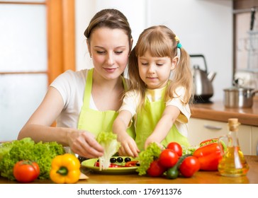 Young Mother And Her Kid Making Vegetable Salad