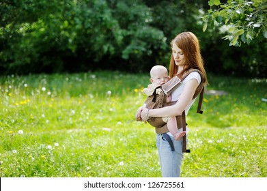 Young Mother And Her Little Baby In A Carrier