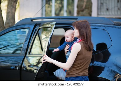 Young Mother With Her Little Baby Getting Into A Car