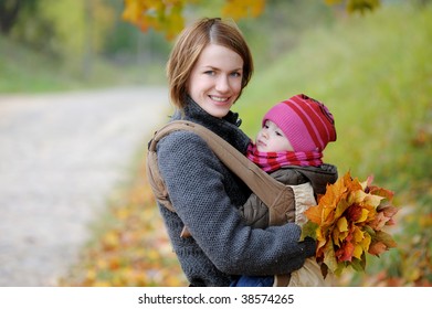 Young Mother With Her Little Baby In A Carrier