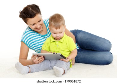Young mother and her little son with computer tablet sit on a white background. Happy family.