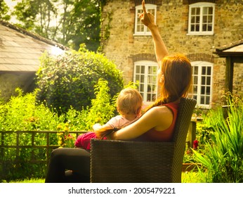 A Young Mother And Her Lovely Baby Girl Enjoy A Sunny Day In Their Holidays Cottage In Dorset, UK