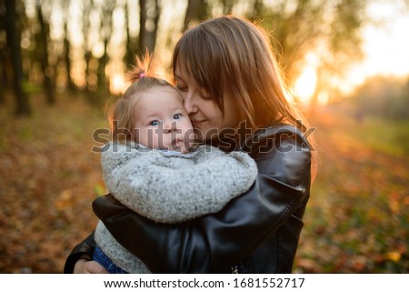 Young mother and her toddler girl in autumn fields