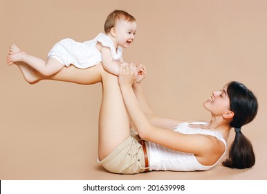 Young Mother Holding Baby, Fun, Exercise, Leisure - Concept