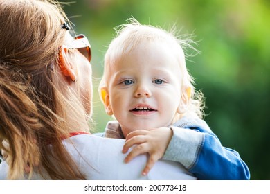 Young Mother Holding Happy Toddler Boy 