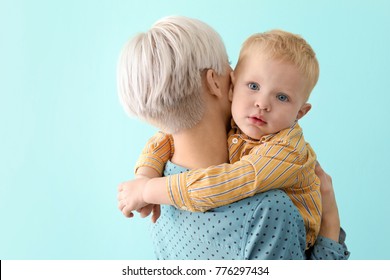 Young Mother Holding Her Baby On Color Background