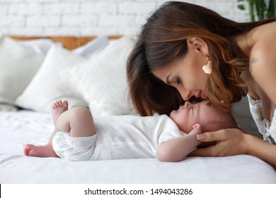 Young mother holding her newborn child. Mom nursing baby. Woman and new born boy relax. Nursery interior. Mother breast feeding baby. Family at home. Portrait of happy mother and baby - Shutterstock ID 1494043286