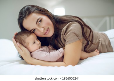 A Young Mother Is Holding Her Newborn Baby. Mother Of A Nursing Baby. Mother Breastfeeding Her Baby. The Family Is At Home. Portrait Of A Happy Mother And Child. High Quality Photo.