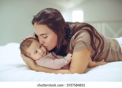 A Young Mother Is Holding Her Newborn Baby. Mother Of A Nursing Baby. Mother Breastfeeding Her Baby. The Family Is At Home. Portrait Of A Happy Mother And Child. High Quality Photo.