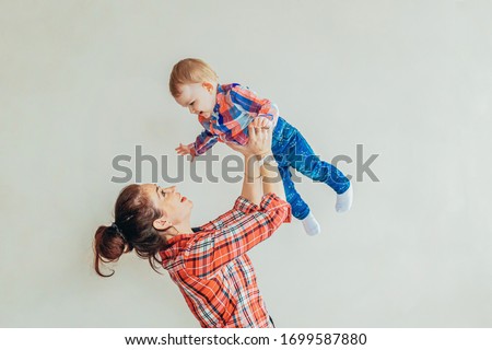 Young mother holding her newborn child. Woman and infant little baby playing isolated white background. Happy mom of breast feeding baby. Family maternity tenderness parenthood responsibility concept