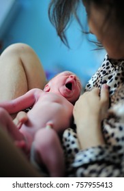 Young Mother Holding Her Newly Born Baby. There Is A Umbilical Cord Still Connect. Baby Is Crying