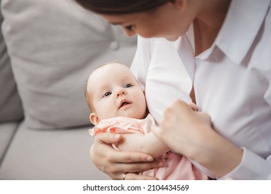 Young Mother Holds Newborn Daughter In Arms, Maternal Instinct.