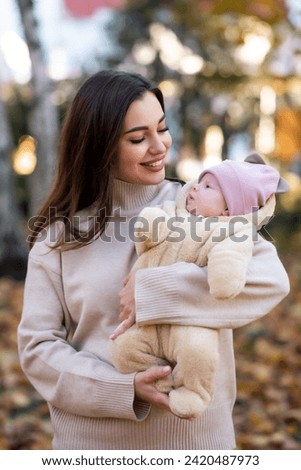 Young mother holds a small child in her arms and smiles