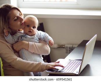 Young Mother In Home Office With Computer And Her Baby. Freelancer Or Blogger, Work And Child Care.