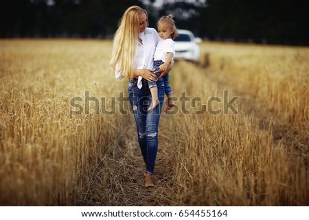 young mother hugging her daughter in a wheat field