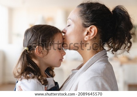 Young mother kissing hugging embracing her small little daughter. Motherhood, parenthood, love and family care concept. Happy Mother`s day!
