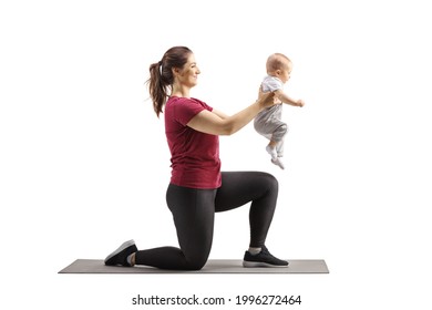 Young Mother Kneeling On An Exercise Mat And Holding Her Baby Isolated On White Background