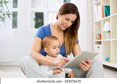 Young Mother Larning Cute Child How To Use Tablet