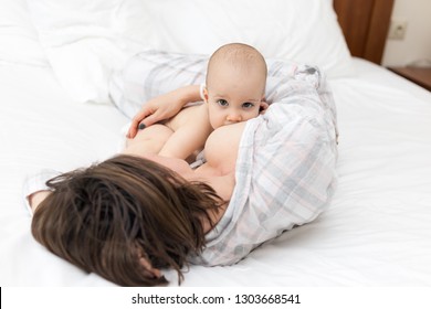 Young Mother Laying Down With Her Baby Boy And Breast Feeding