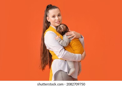 Young Mother With Little Baby In Sling On Color Background